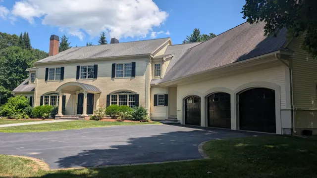 Cream colonial with a three-car garage
