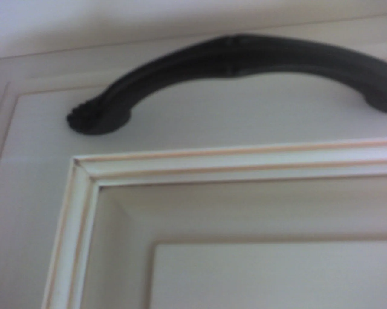 Painted cabinet door with a black handle, up close