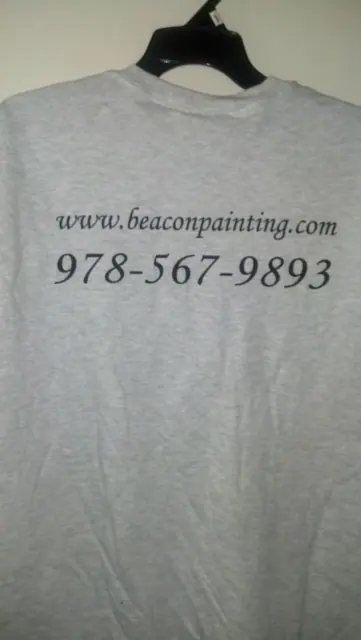 Back of a grey Beacon crew T-shirt printed with the web address and phone number
