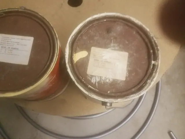 Two opened paint cans on a Beacon job, lids labelled with the color