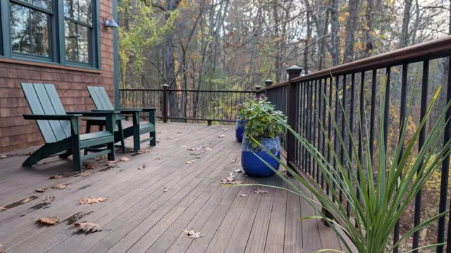 Stained deck with dark rails and Adirondack chairs