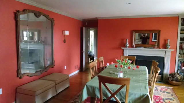 Dining room painted warm coral with white trim
