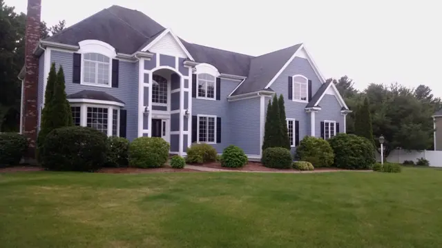 Two-story colonial in dove gray with dark shutters