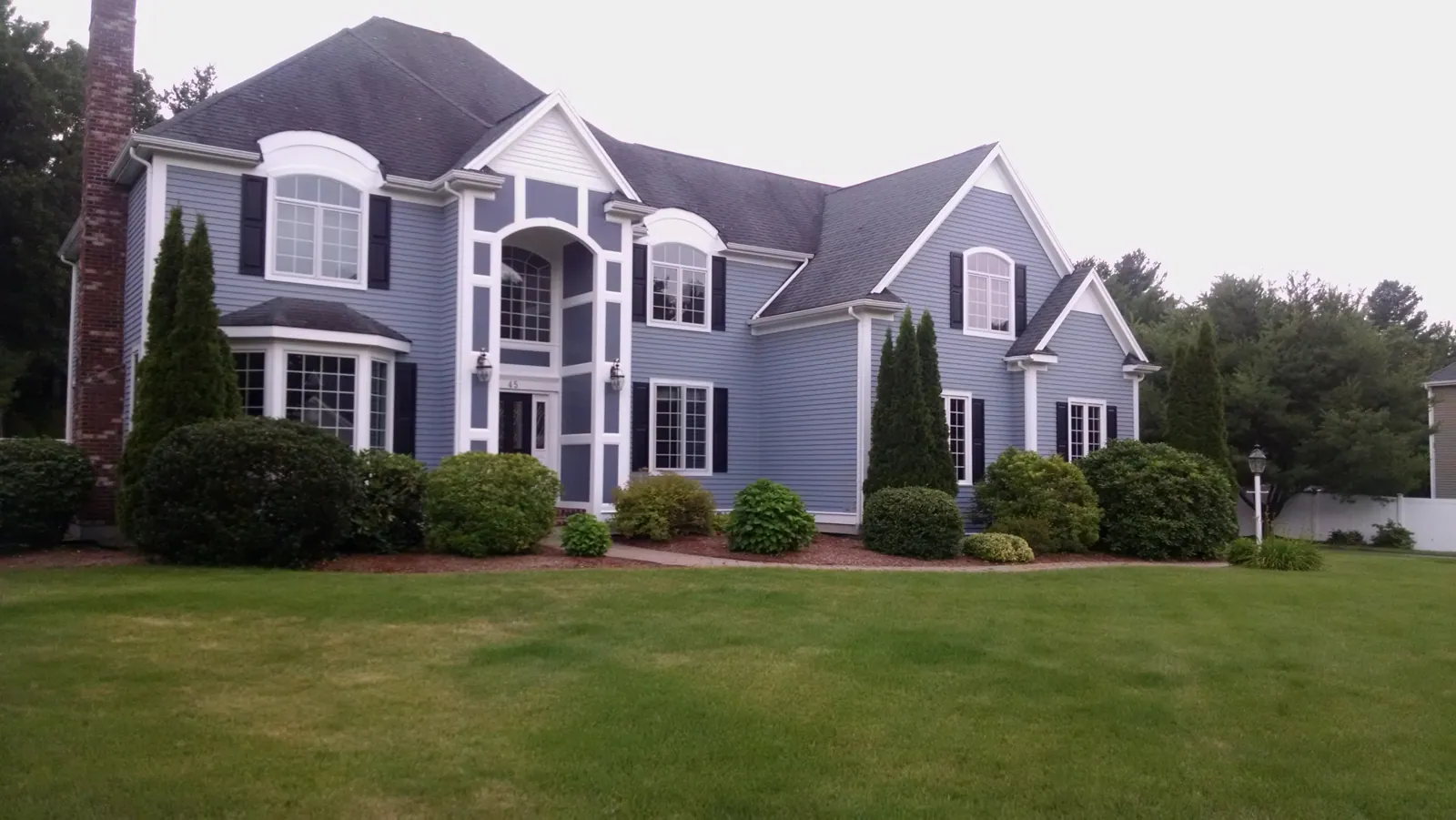 Two-story colonial in dove gray with dark shutters