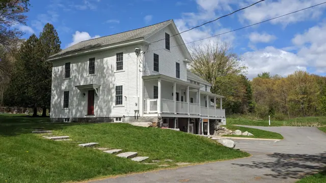 White farmhouse with a wraparound porch