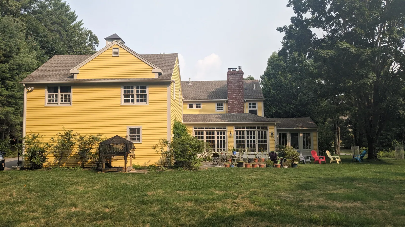 Colonial yellow farmhouse with a carriage barn