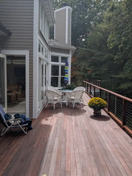 Stained hardwood deck with cable railing and patio table