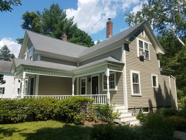 Sage farmhouse with a white porch