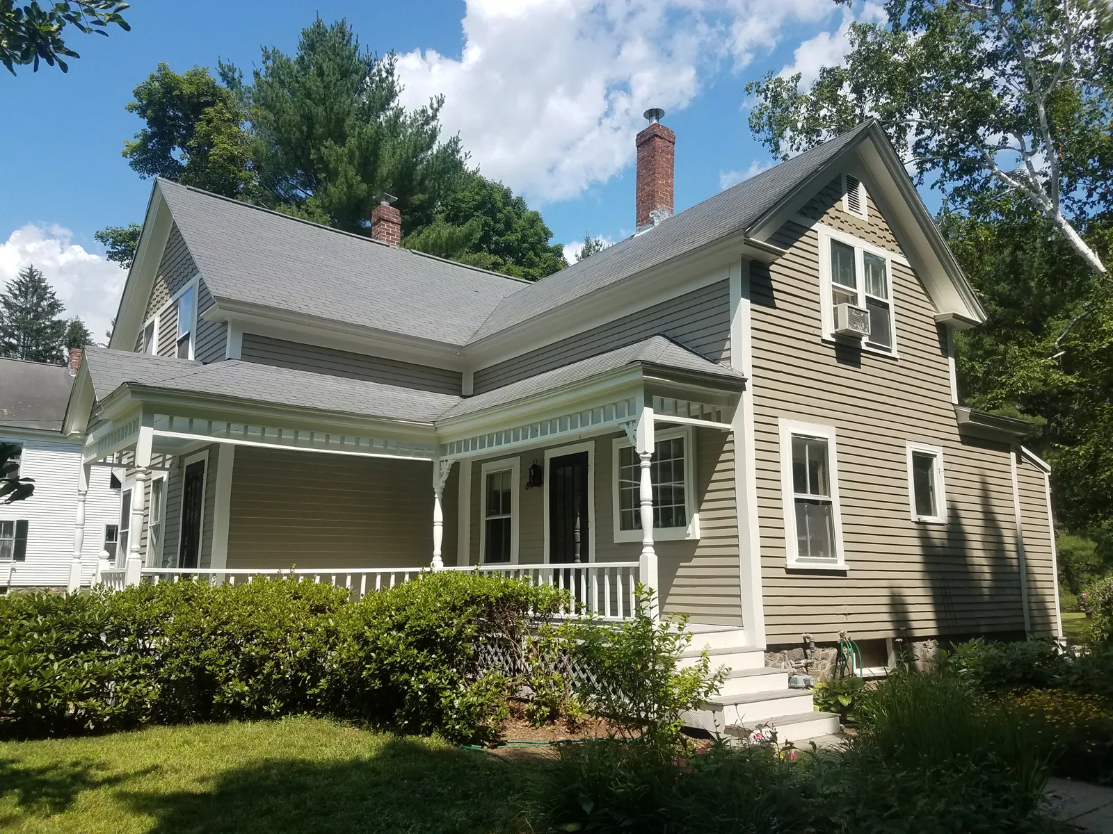 Sage farmhouse with a white porch