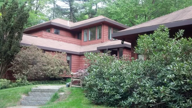 Red cedar home above stone steps and gardens