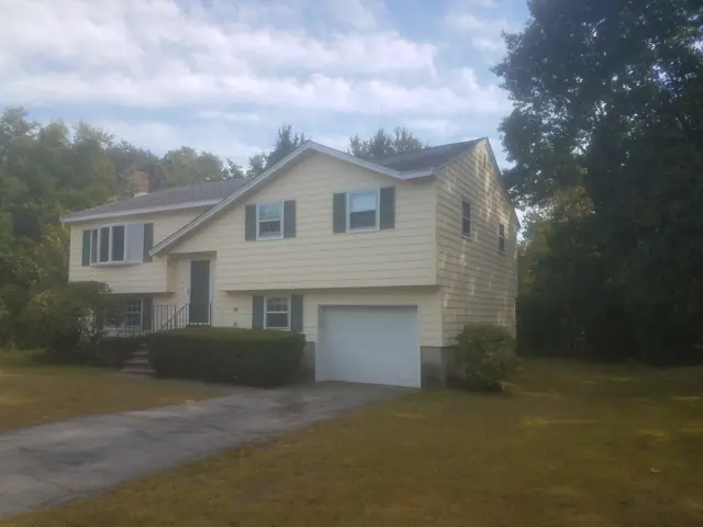 Pale yellow home with a white garage